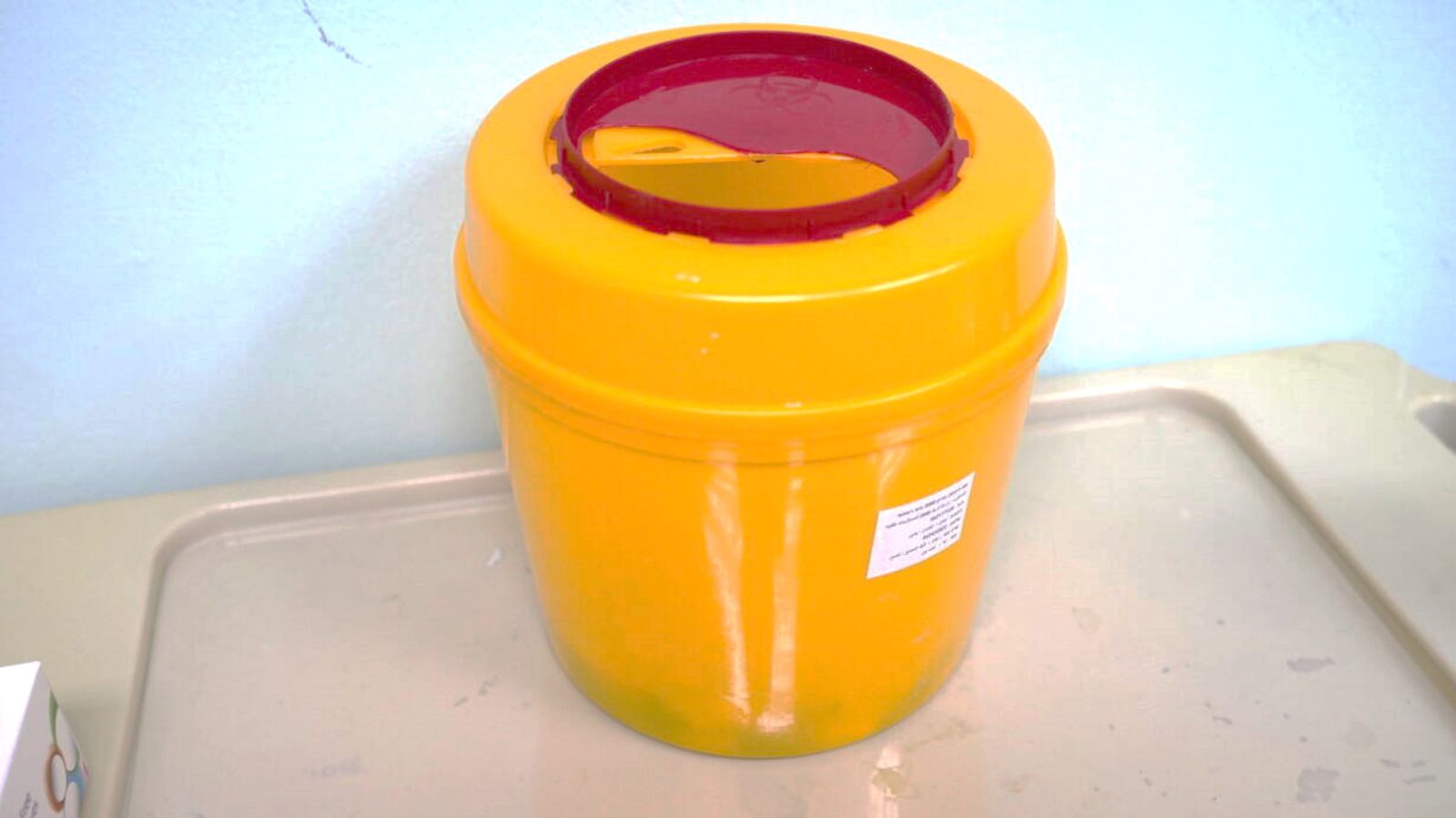 A yellow container with a red lid