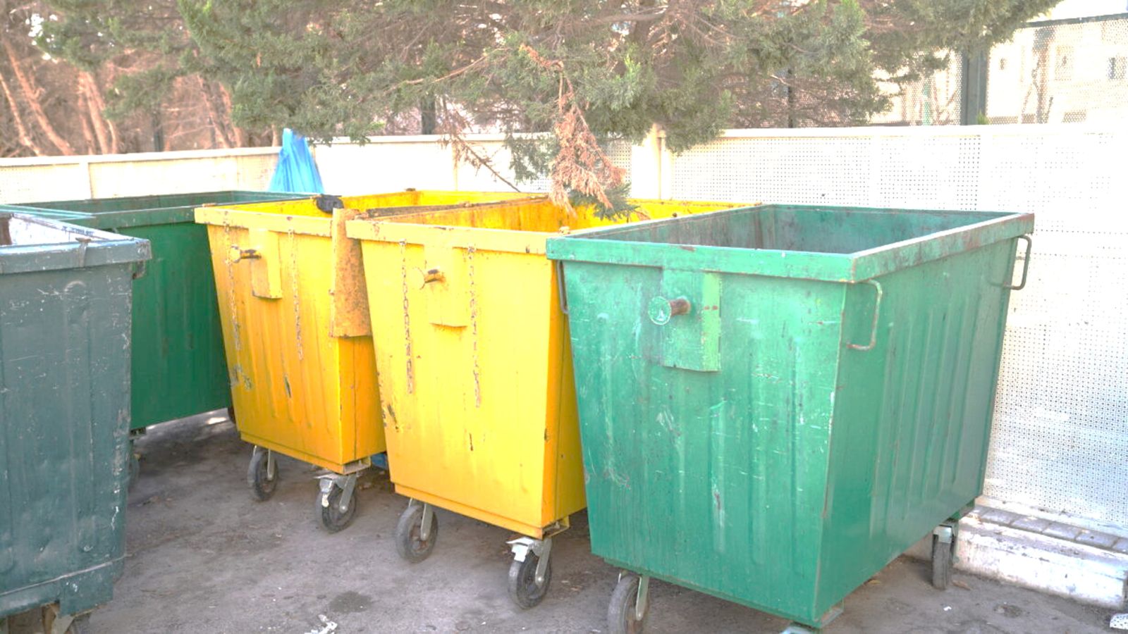 A group of yellow and green trash cans