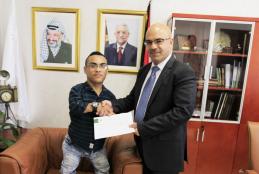 University President Assistant for Administrative and Financial Affairs Mr. Faleh Abu Arra delivered the scholarship decision to the student in representing Chairman of Directors Board.